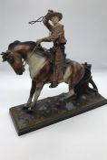 A 1920's cold painted spelter cowboy about to throw his lasso, the tree stump behind conceals the