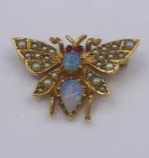 An Opal Butterfly brooch in yellow metal, comprising foir wings, each grain set with a series of