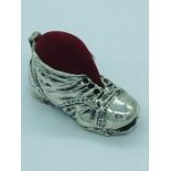 A silver boot pincushion