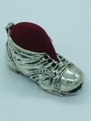 A silver boot pincushion