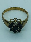 A 9ct yellow gold ring in daisy style with sapphires, missing a single stone, (1.5g)