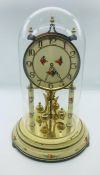 A Decorative Clock under a glass dome.