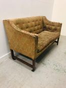 A Regency Mahogany framed sofa with rectangular back and brass castors.