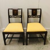 Pair of Empire style chairs with decorative back panels and yellow upholstered chair pads