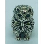 A silver figure of a Persian cat with emerald eyes