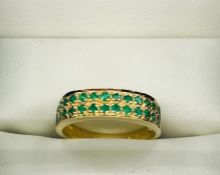 A 9ct yellow gold double row half eternity style ring with emeralds.