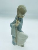 Lladro figurine of a young boy kneeling holding a stick