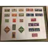 A framed collection of stamps from New Zealand and South Africa along with a worldwide stamp album.