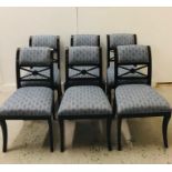 A set of six contemporary blue fabric upholstered dining chairs with brass stud detailing to back,
