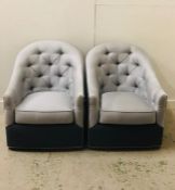 Two Charcoal and Light grey upholstered swivel style chairs.