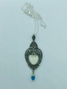 A silver pendant necklace set with marcasite's and blue topaz drop