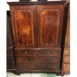 A Mahogany Linen press, the upper part adapted for hanging and enclosed by a pair of panelled doors,