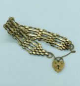 A 9ct yellow gold gate bracelet with a heart shaped fastener.(10.5g)