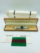 A Gucci Gentleman's watch on a stainless steel and gold tone bracelet with black face (1988) and