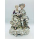 A Hand painted figure of a woman and a man seated.