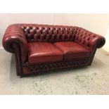 A Chesterfield style Ox Blood two seater sofa