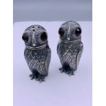 A pair of condiments in the form of owls with glass eyes stamped 800