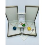 Three boxed items of contemporary glass jewellery, to include two Murano glass heart pendants and an