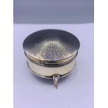 A sliver lidded circular jewellery box on tripod support