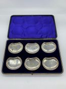 A boxed set of silver butter dishes or even ashtrays, hallmarked.