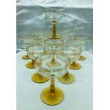 Eleven amber stemmed champagne coupes with gold detailing to rims