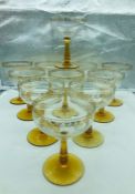 Eleven amber stemmed champagne coupes with gold detailing to rims