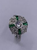 A silver art deco style ring set with emeralds and CZ's