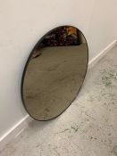 Circular mirror with thin black metal frame.