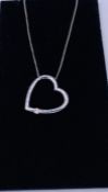 A 9ct white gold pendant necklace in the form of a heart set with a diamond on gold chain