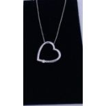 A 9ct white gold pendant necklace in the form of a heart set with a diamond on gold chain