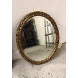 Oval gilt mirror with scroll detail