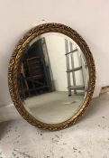 Oval gilt mirror with scroll detail