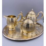 A White Metal, machine tooled tea set to include tray, teapot, sugar bowl and milk jug.