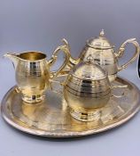 A White Metal, machine tooled tea set to include tray, teapot, sugar bowl and milk jug.