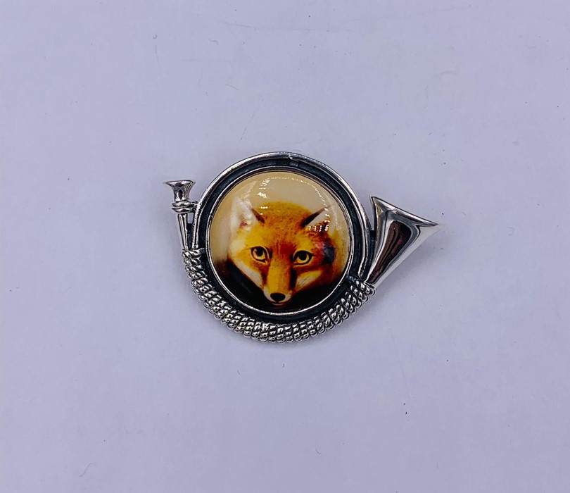 A silver and enamel set brooch/pendant depicting fox and hunting horn