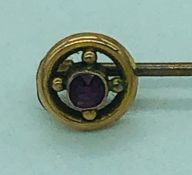 A 9ct gold and ruby lapel pin