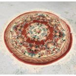 A Circular rug with a floral pattern and tassled edges 163cm diameter