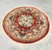 A Circular rug with a floral pattern and tassled edges 163cm diameter
