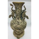 A Tall white metal Chinese vase on stand with Dragon themed handles.