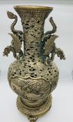 A Tall white metal Chinese vase on stand with Dragon themed handles.