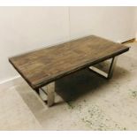 A Grayson Industrial reclaimed solid wood coffee table with glass top and chrome legs.