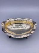 A Hammered silver bowl on claw feet, marked 800