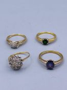 A selection of four 9ct gold rings with various settings.