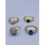 A selection of four 9ct gold rings with various settings.