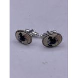 A pair of silver pictorial cufflinks depicting a dog