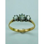 A three stone diamond ring on yellow gold.