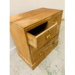 A Two over two pine chest of drawers with brass cup handles.