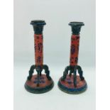 A Pair of candlestick with a red background and floral pattern