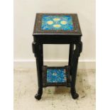 An ebonised pot stand with tiled top and lower shelf.