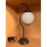 A Reproduction desk light with glass globe shade.